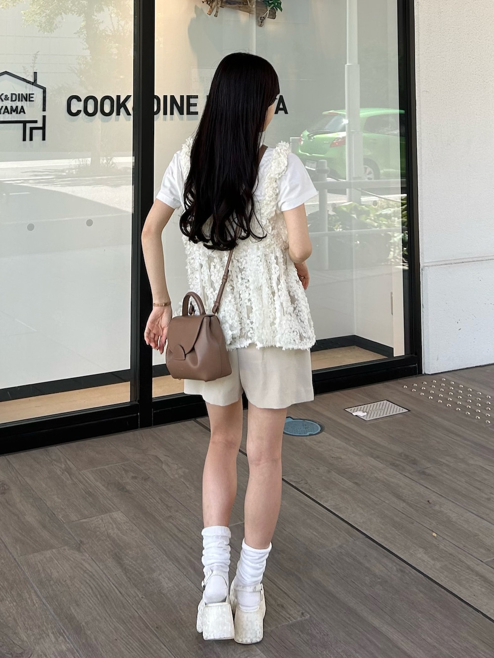 ブラウン系のバッグ、ホワイト系のキャミソール、ホワイト系のTシャツ/カットソーを着用したレディースの春コーディネートの3枚目の写真