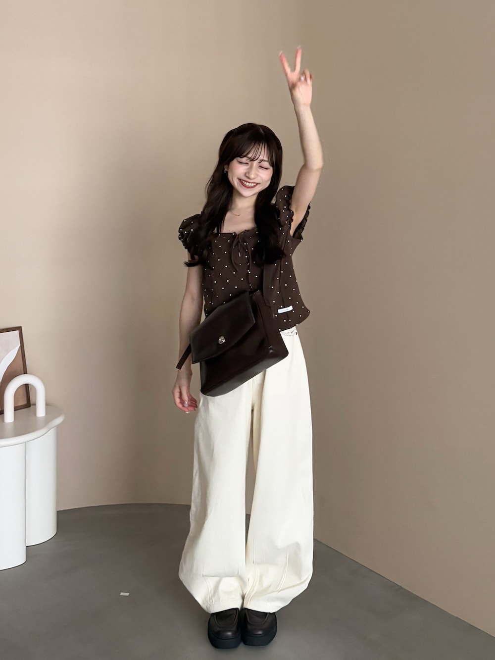 ブラウン系のローファー、ホワイト系のデニムパンツ、ブラウン系のバッグを着用したレディースの秋コーディネートの2枚目の写真
