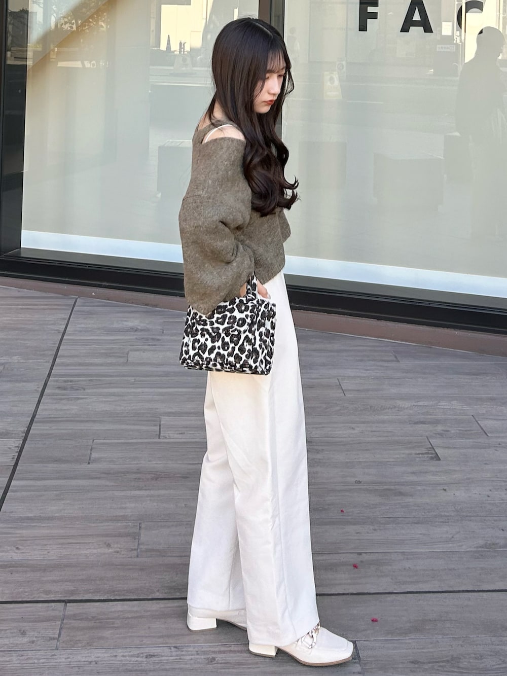 ブラック系のショルダーバッグ、ホワイト系のスラックス、ブラウン系のカーディガン/ボレロを着用したレディースの秋コーディネートの4枚目の写真