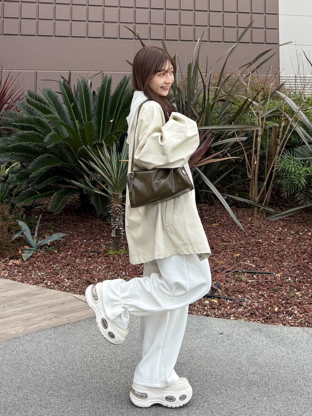 ホワイト系のスウェットパンツ、ピンク系のカーディガン/ボレロ、グリーン系のトートバッグを着用したレディースの春コーディネートの3枚目の写真