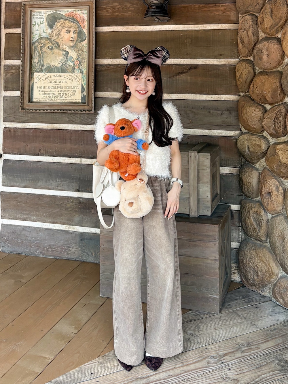 ブラウン系のパンプス、ブラウン系のデニムパンツ、ホワイト系のボストンバッグを着用したレディースの秋コーディネートの2枚目の写真