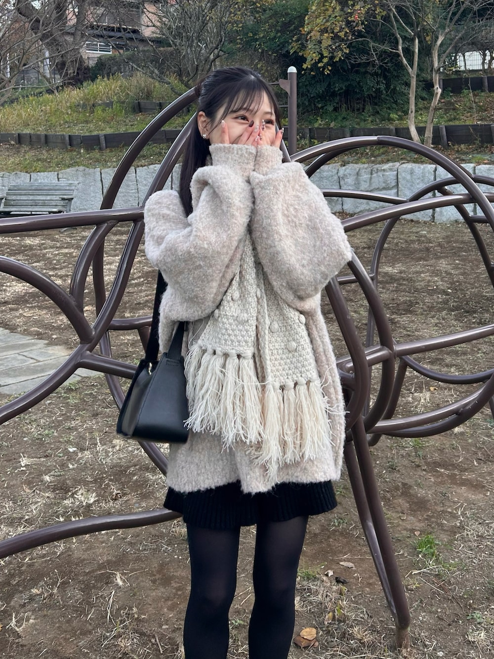 ホワイト系のダッフルコート、ブラック系のショルダーバッグ、ブラック系のブーツを着用したレディースの冬コーディネートの4枚目の写真