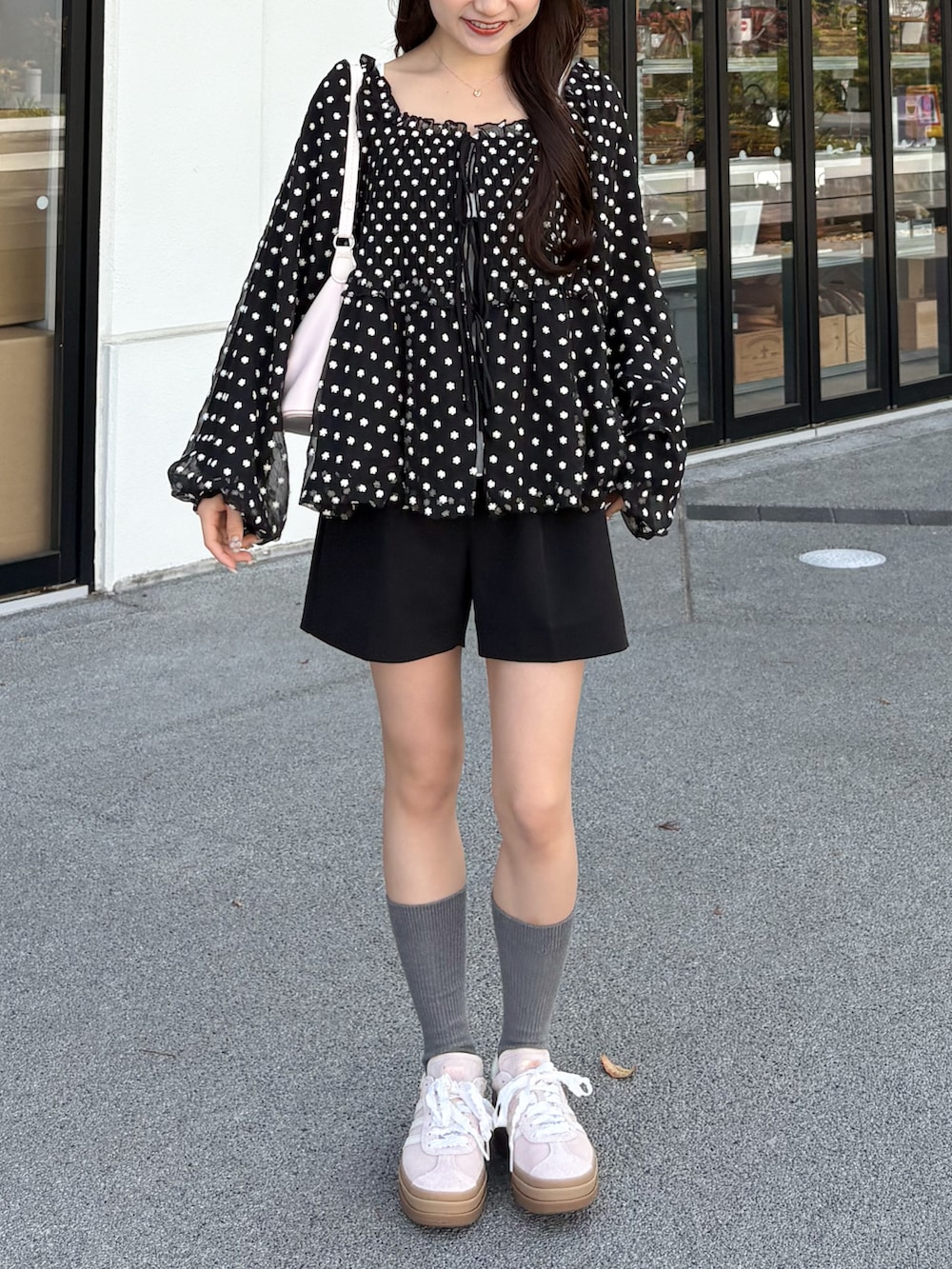 ピンク系のスニーカー、ブラック系のその他パンツ、ブラック系のシャツ/ブラウスを着用したレディースの春コーディネートの3枚目の写真