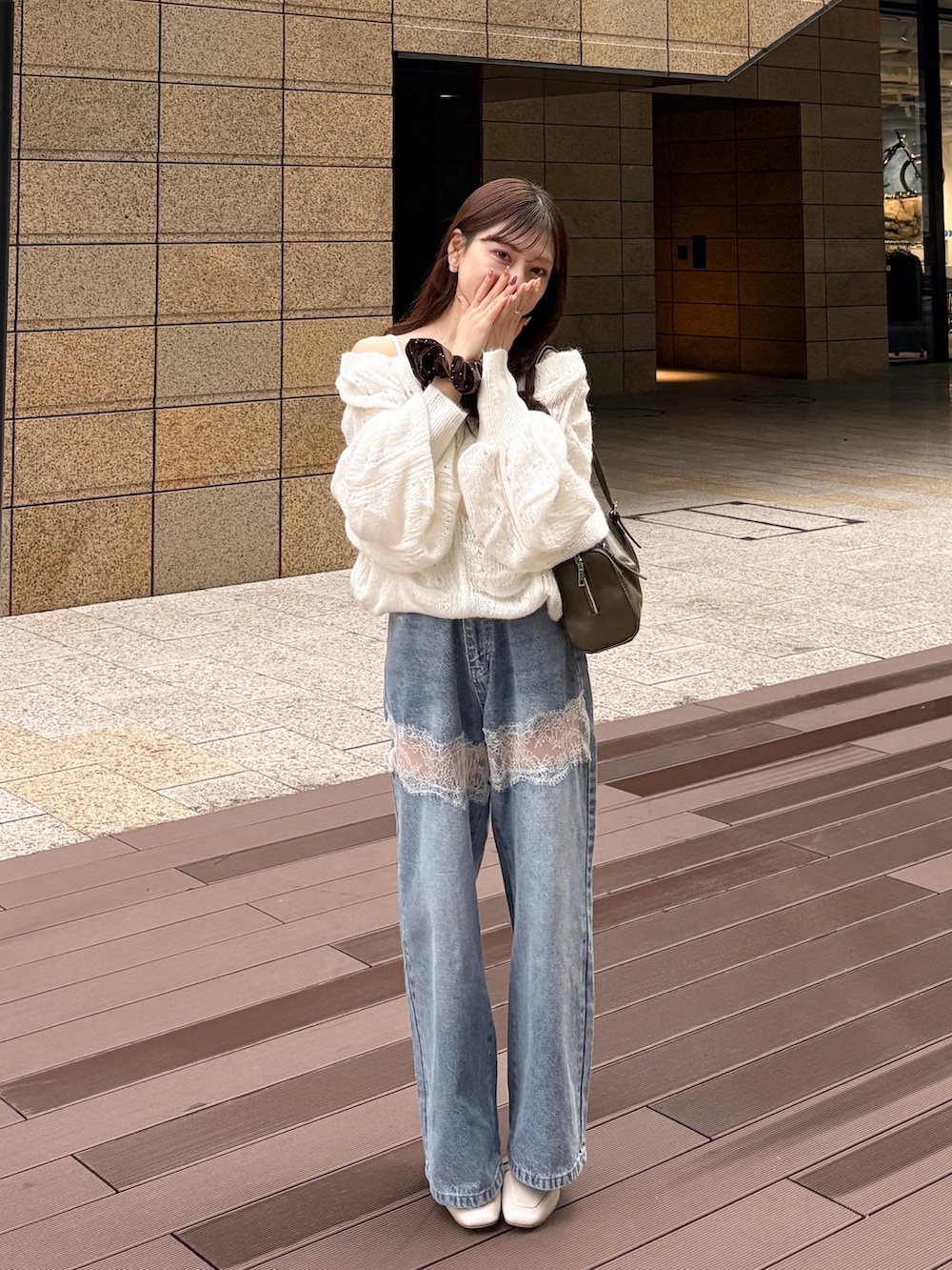 ホワイト系のニット/セーター、ブルー系のデニムパンツ、グリーン系のトートバッグを着用したレディースの秋コーディネートの4枚目の写真