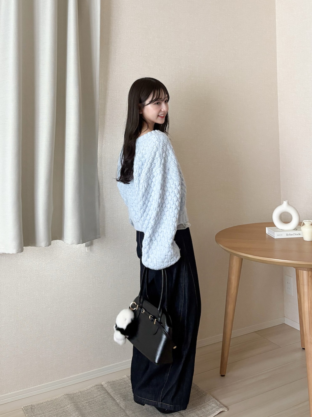 ブルー系のカーディガン/ボレロ、ブラック系のボストンバッグ、ブルー系のデニムパンツを着用したレディースの秋コーディネートの2枚目の写真