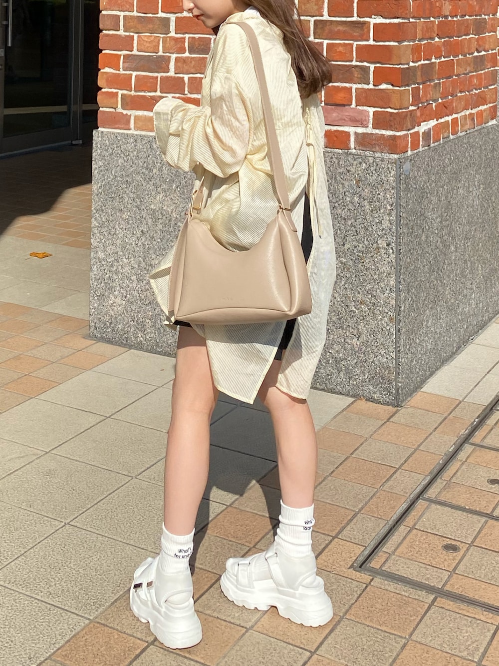 ブラック系のその他パンツ、ホワイト系のTシャツ/カットソー、ホワイト系のサンダルを着用したレディースの夏コーディネートの4枚目の写真