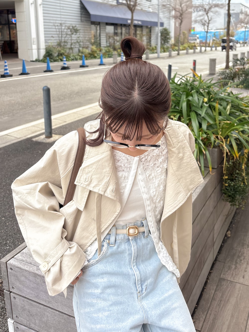 ホワイト系のトレンチコート、ホワイト系のシャツ/ブラウス、ブルー系のデニムパンツを着用したレディースの春コーディネートの2枚目の写真