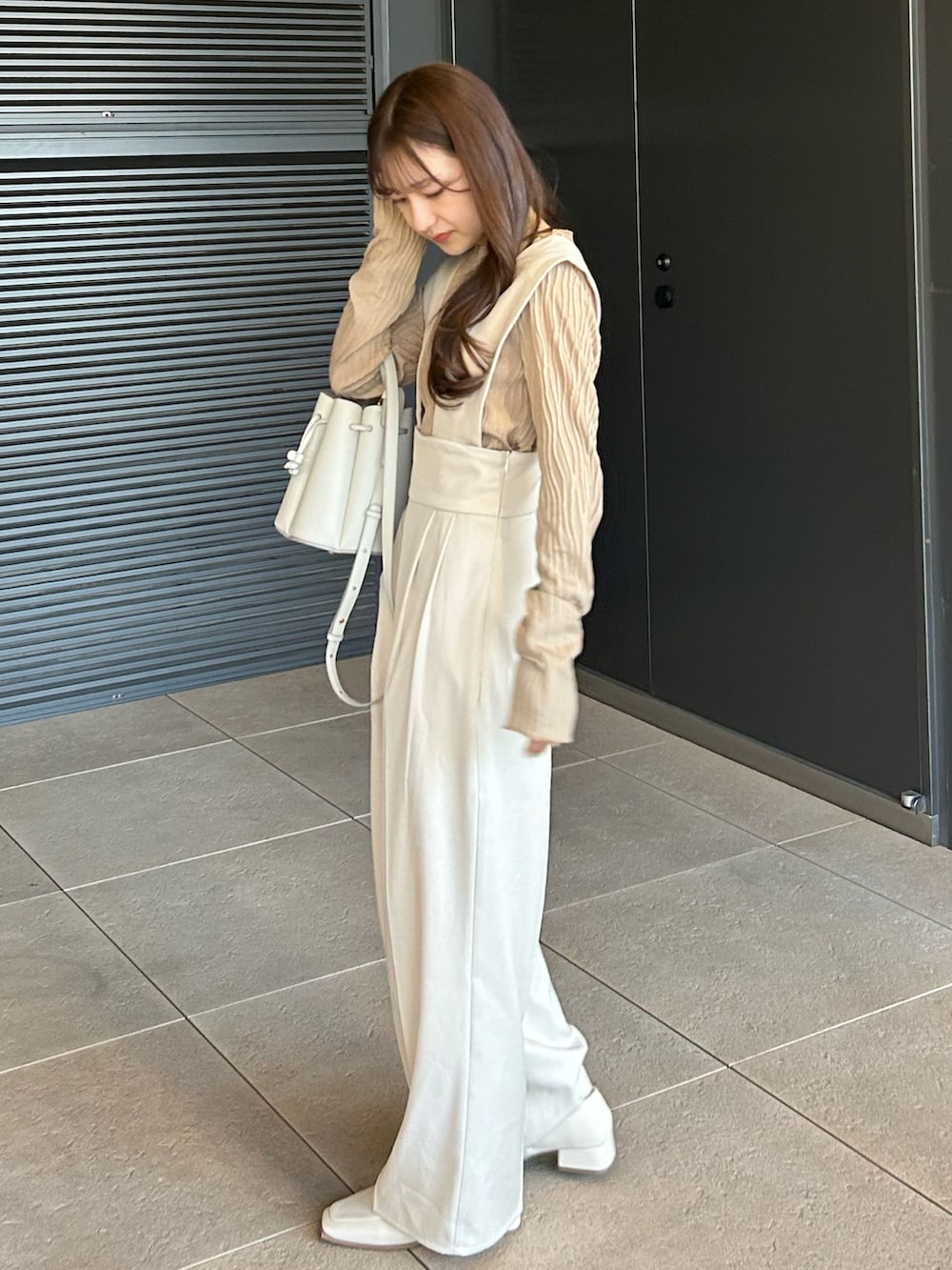 ホワイト系のその他パンツ、ホワイト系のバッグ、ベージュ系のトップスを着用したレディースの春コーディネートの2枚目の写真