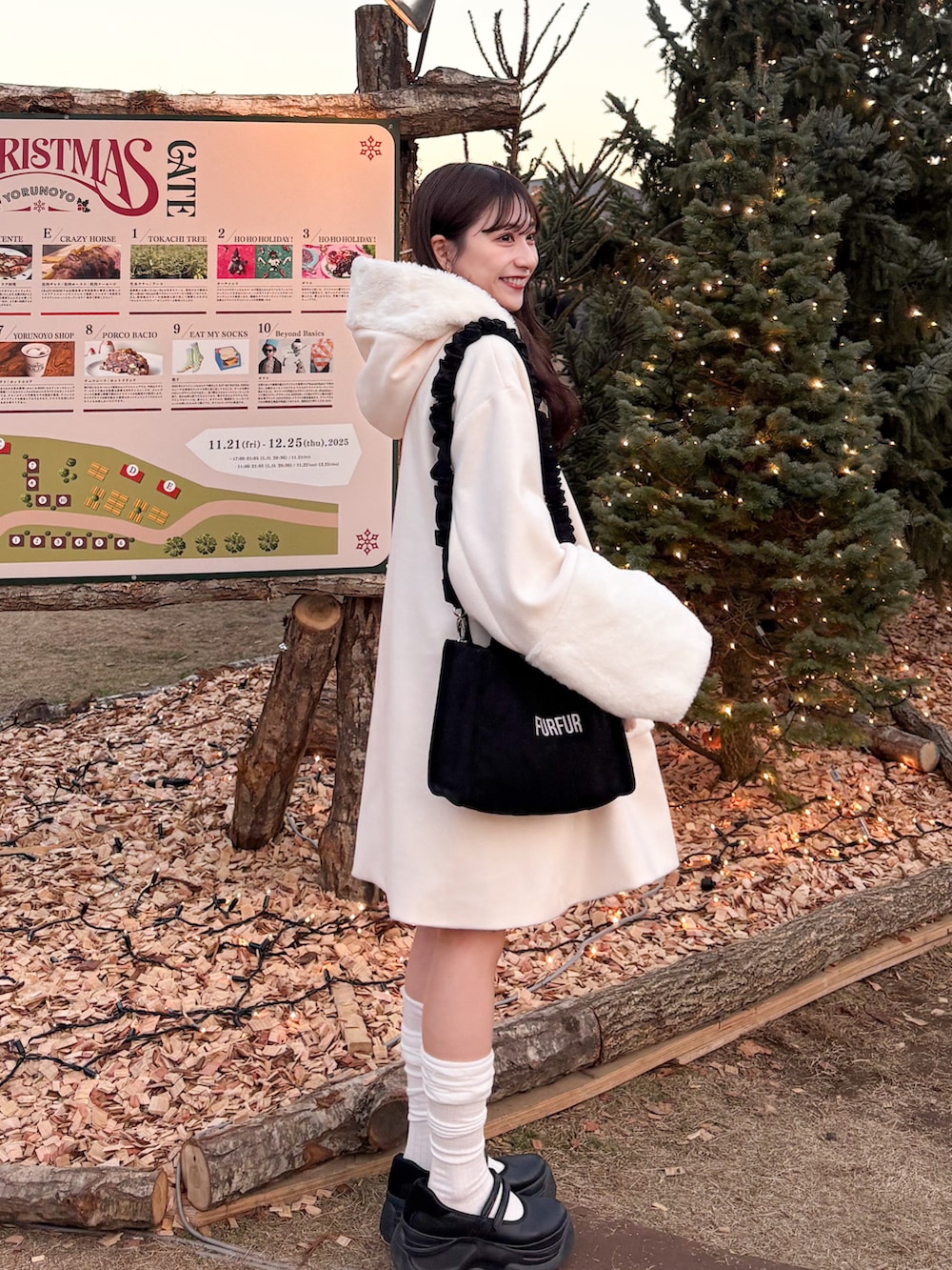 ブラック系のショルダーバッグ、ホワイト系のジャケット/アウター、ブラック系のサンダルを着用したレディースの冬コーディネートの2枚目の写真