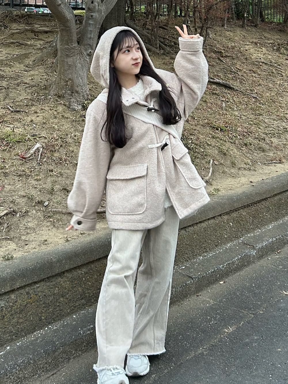 ベージュ系のデニムパンツ、ホワイト系のダッフルコート、ホワイト系のカーディガン/ボレロを着用したレディースの冬コーディネートの2枚目の写真