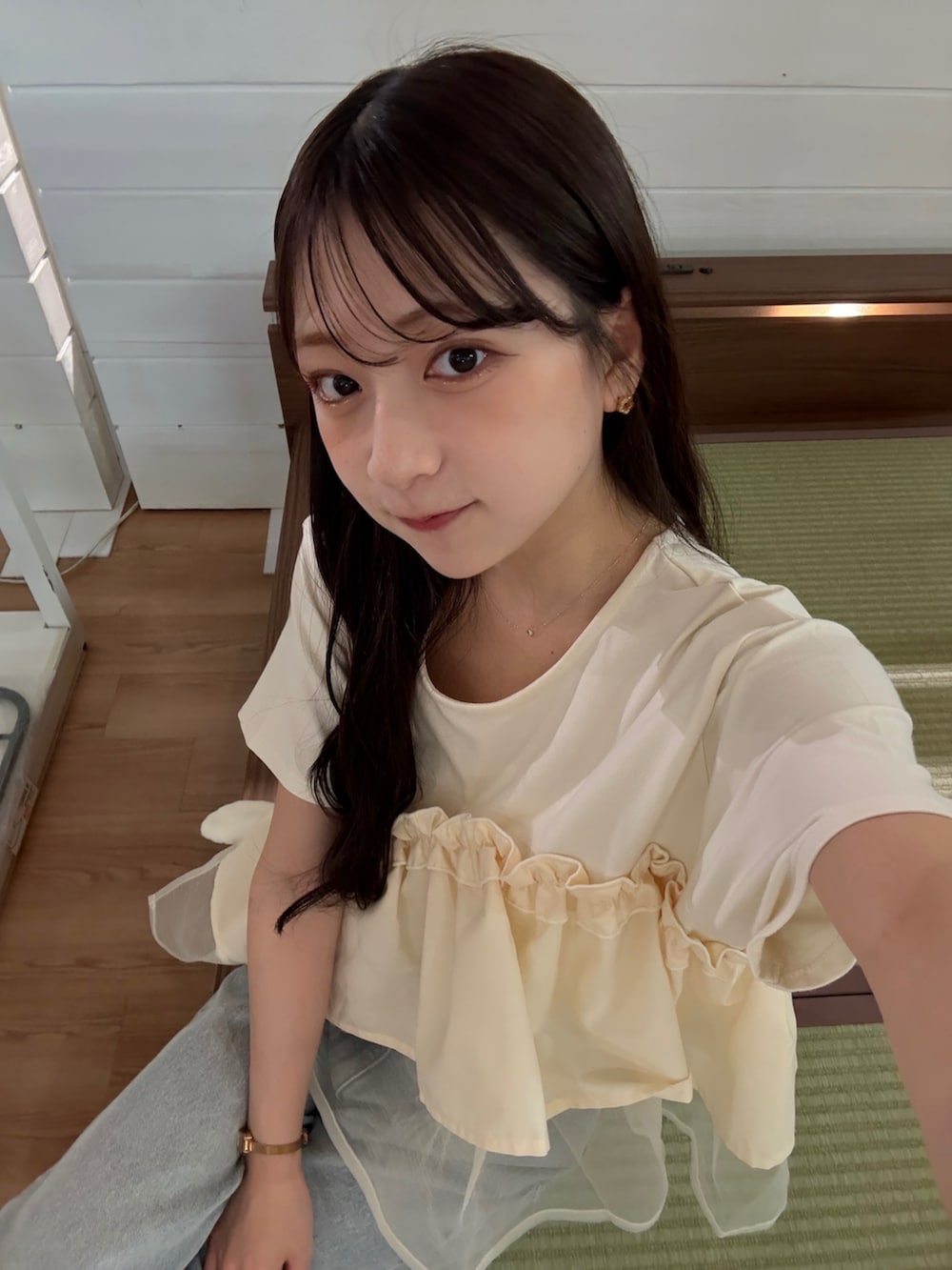 ベージュ系のTシャツ/カットソー、ベージュ系のハンドバッグ、ホワイト系のスニーカーを着用したレディースの夏コーディネートの3枚目の写真