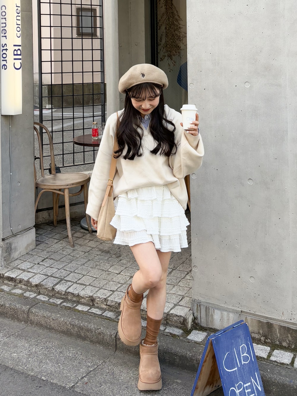 ホワイト系のニット/セーター、ベージュ系のショルダーバッグ、ホワイト系のスカートを着用したレディースの春コーディネートの3枚目の写真