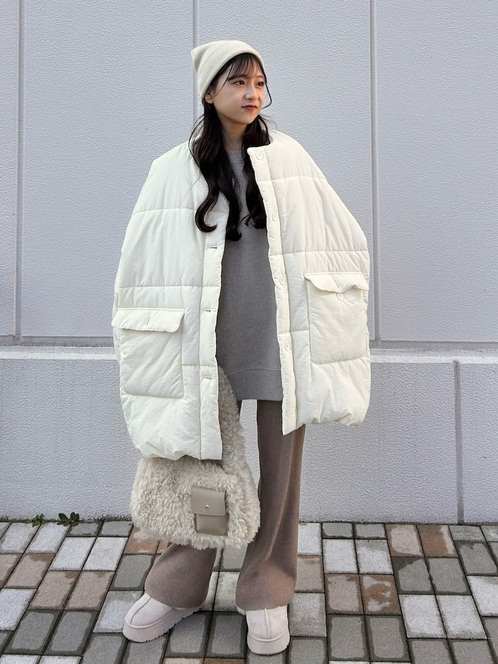 ホワイト系のダウンジャケット/コート、ホワイト系のハンドバッグ、グレー系のスウェットを着用したレディースの冬コーディネートの3枚目の写真