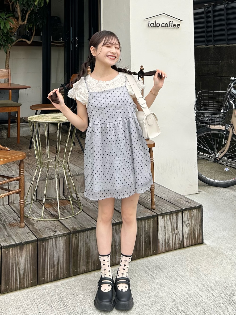 グレー系のカーディガン/ボレロ、ホワイト系のショルダーバッグ、ホワイト系のシャツ/ブラウスを着用したレディースの夏コーディネートの3枚目の写真