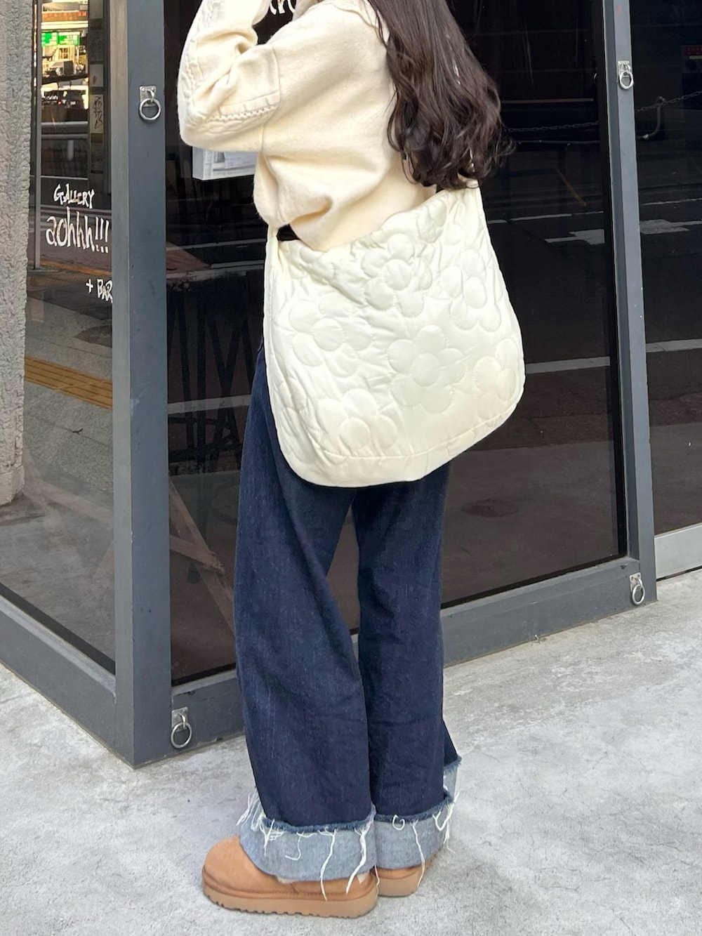 ブルー系のデニムパンツ、ホワイト系のショルダーバッグ、ホワイト系のニット/セーターを着用したレディースの秋コーディネートの3枚目の写真