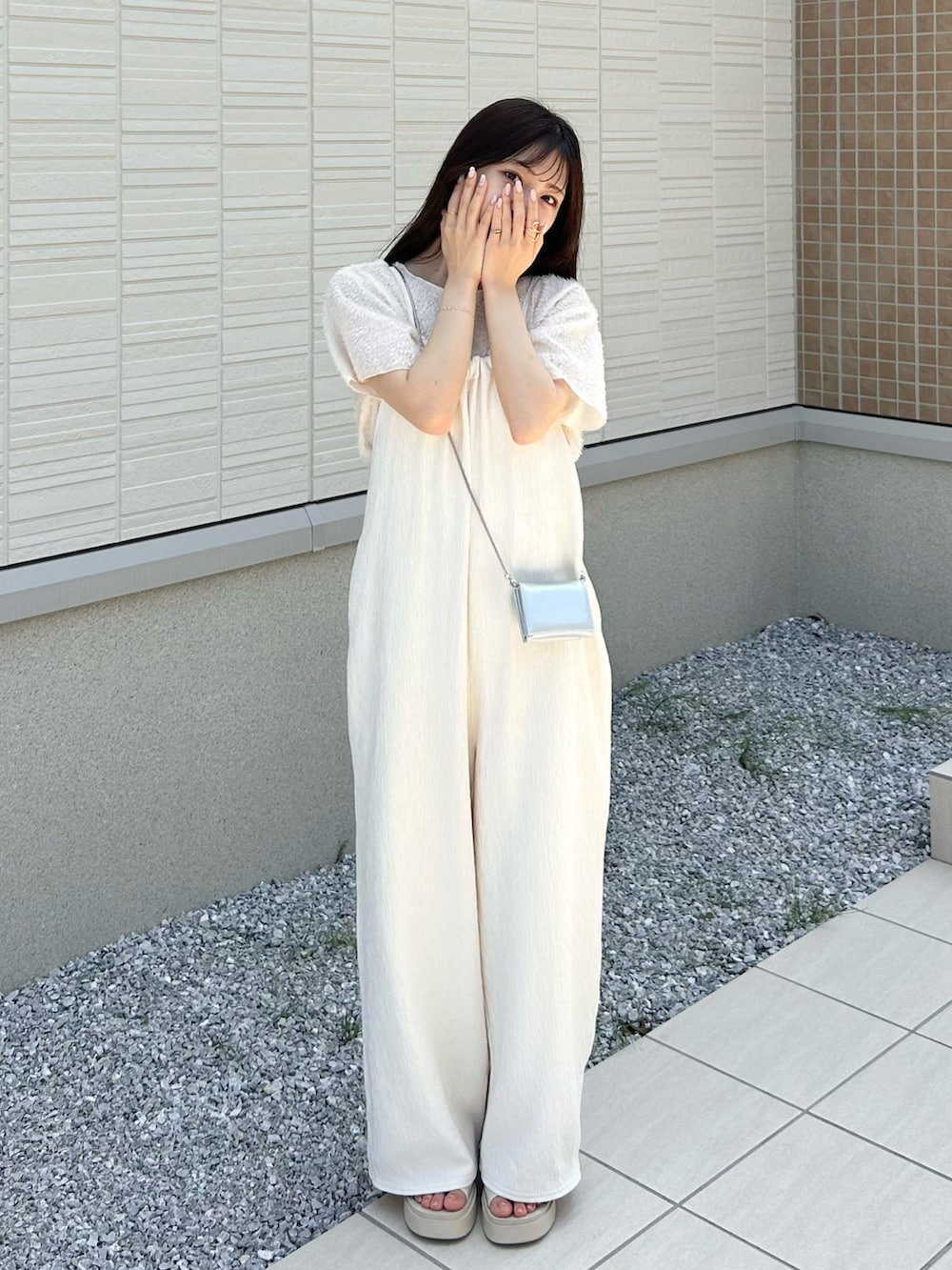 ホワイト系のサンダル、ホワイト系のサロペット/オーバーオール、シルバー系のショルダーバッグを着用したレディースの夏コーディネートの3枚目の写真
