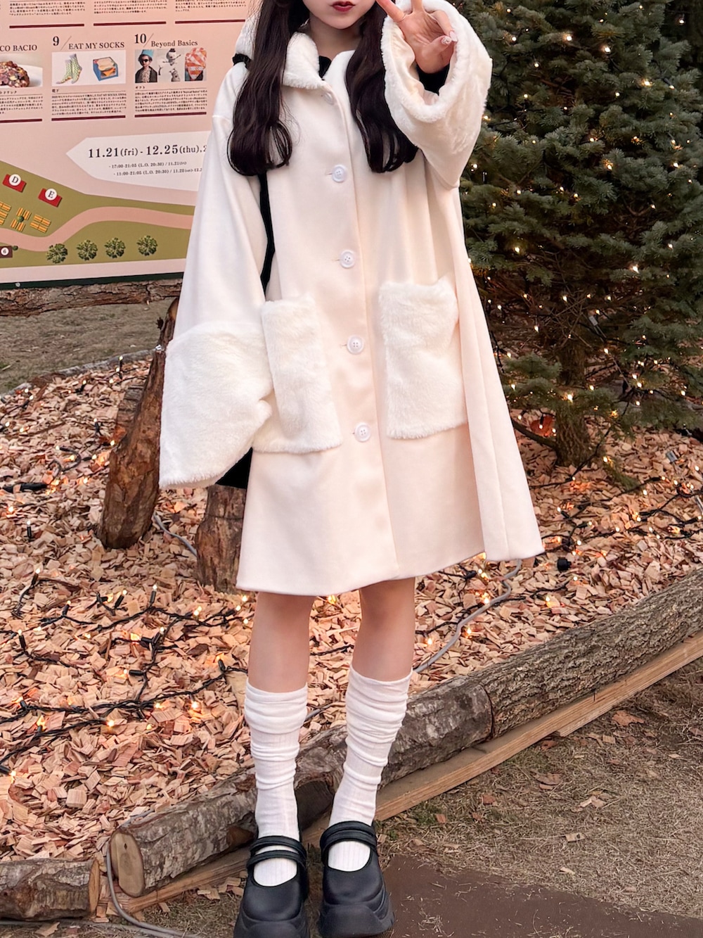 ブラック系のショルダーバッグ、ホワイト系のジャケット/アウター、ブラック系のサンダルを着用したレディースの冬コーディネートの3枚目の写真