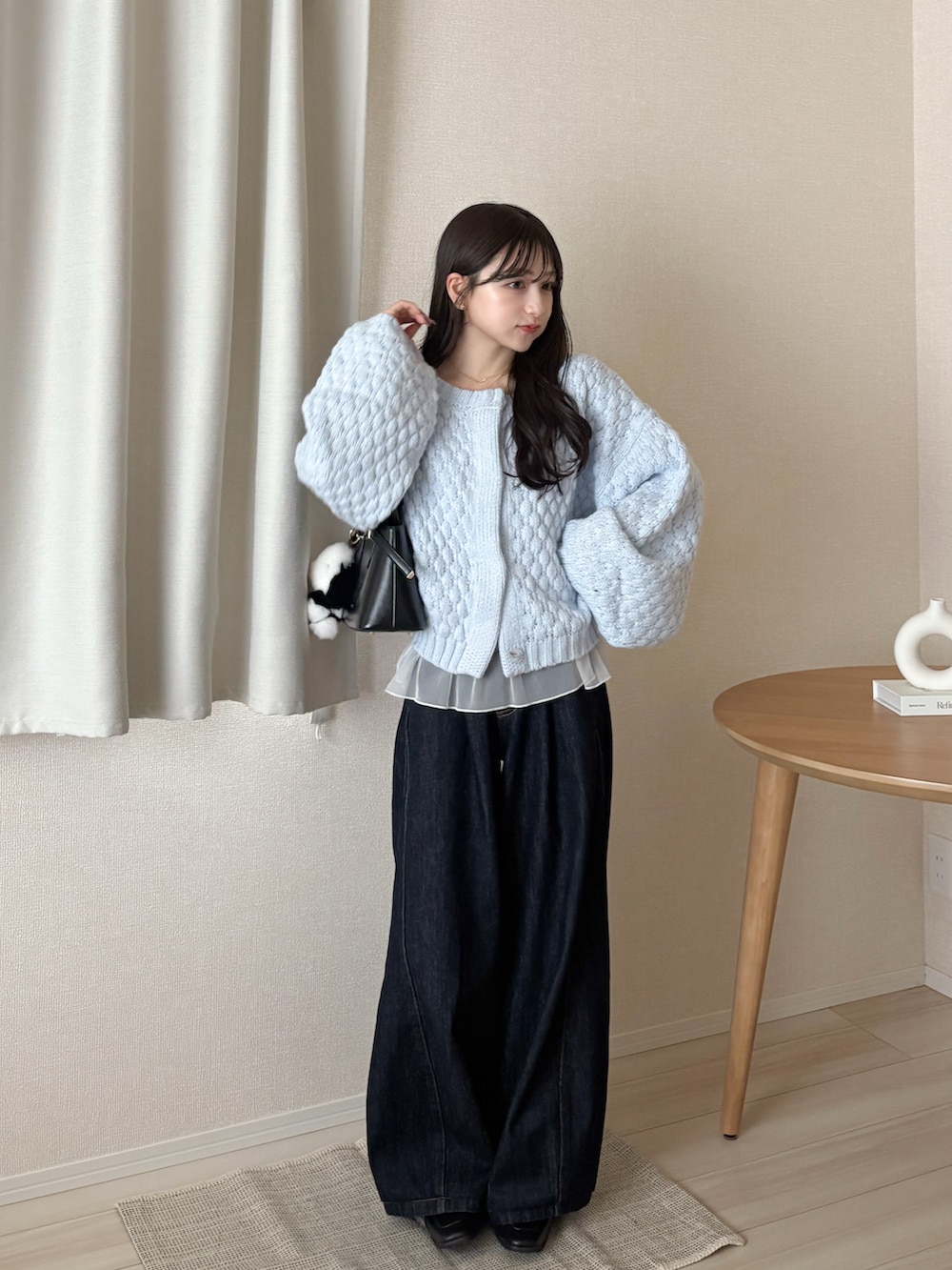 ブルー系のカーディガン/ボレロ、ブラック系のボストンバッグ、ブルー系のデニムパンツを着用したレディースの秋コーディネートの4枚目の写真