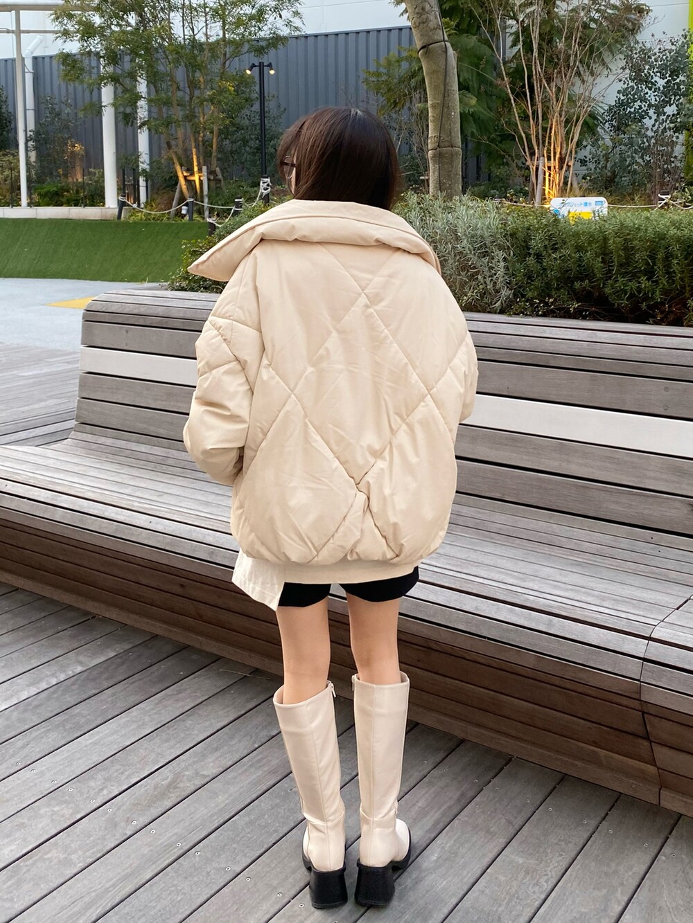 ベージュ系のショルダーバッグ、ホワイト系のTシャツ/カットソー、ホワイト系のダウンジャケット/コートを着用したレディースの冬コーディネートの3枚目の写真