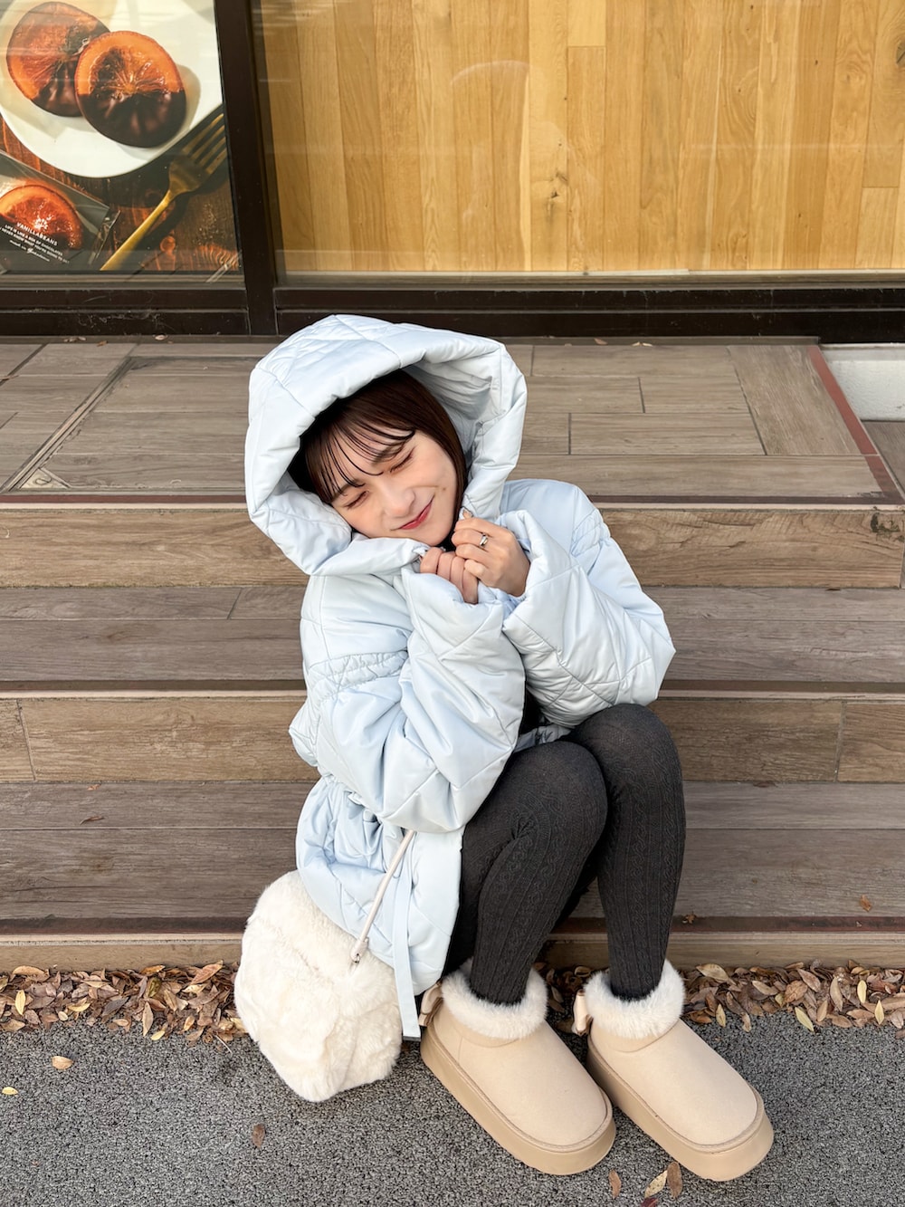 ブルー系のその他アウター、ホワイト系のハンドバッグ、ベージュ系のブーツを着用したレディースの秋コーディネートの2枚目の写真