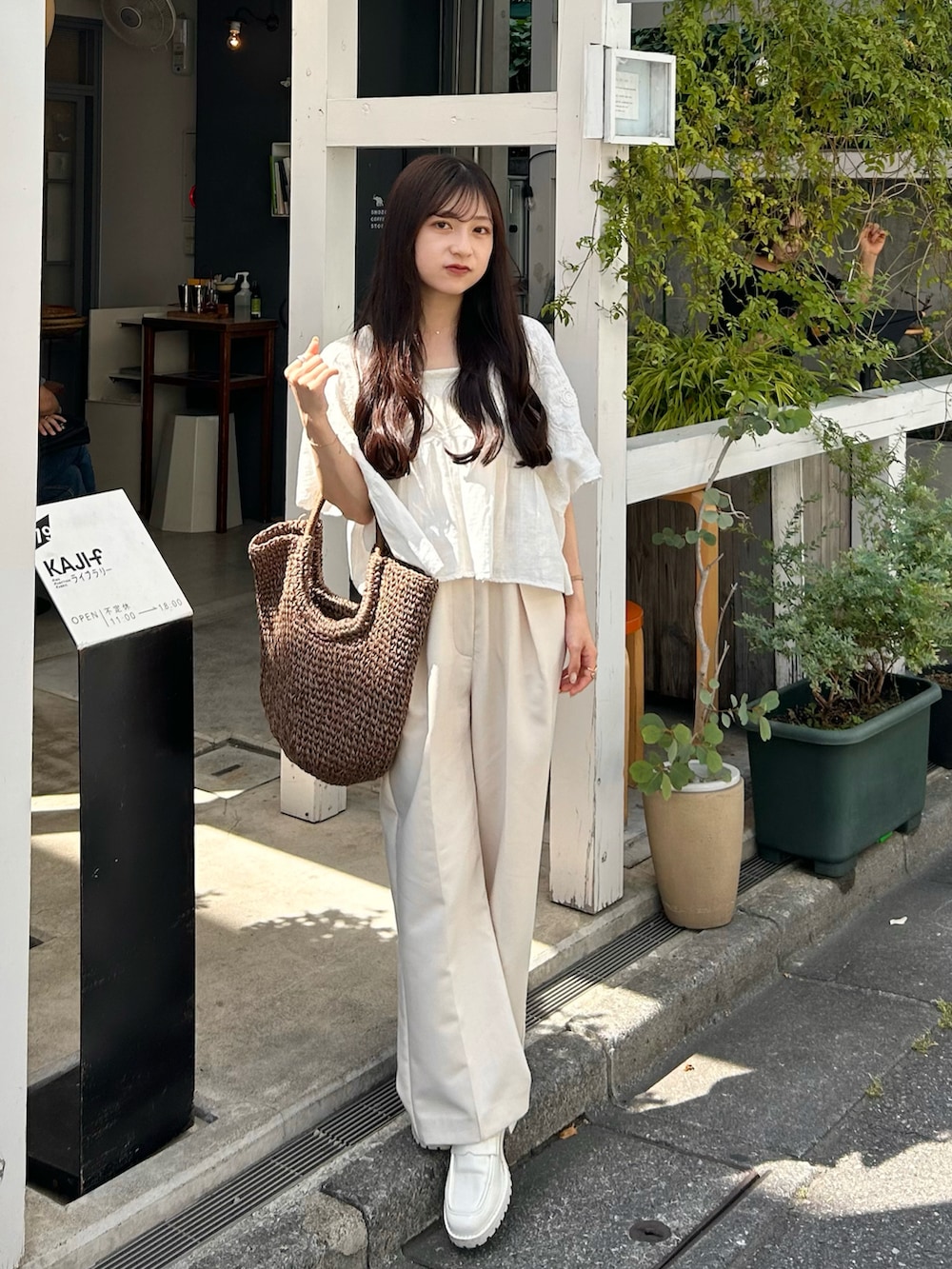 ホワイト系のその他パンツ、ブラウン系のトートバッグ、ホワイト系のシャツ/ブラウスを着用したレディースの夏コーディネートの3枚目の写真