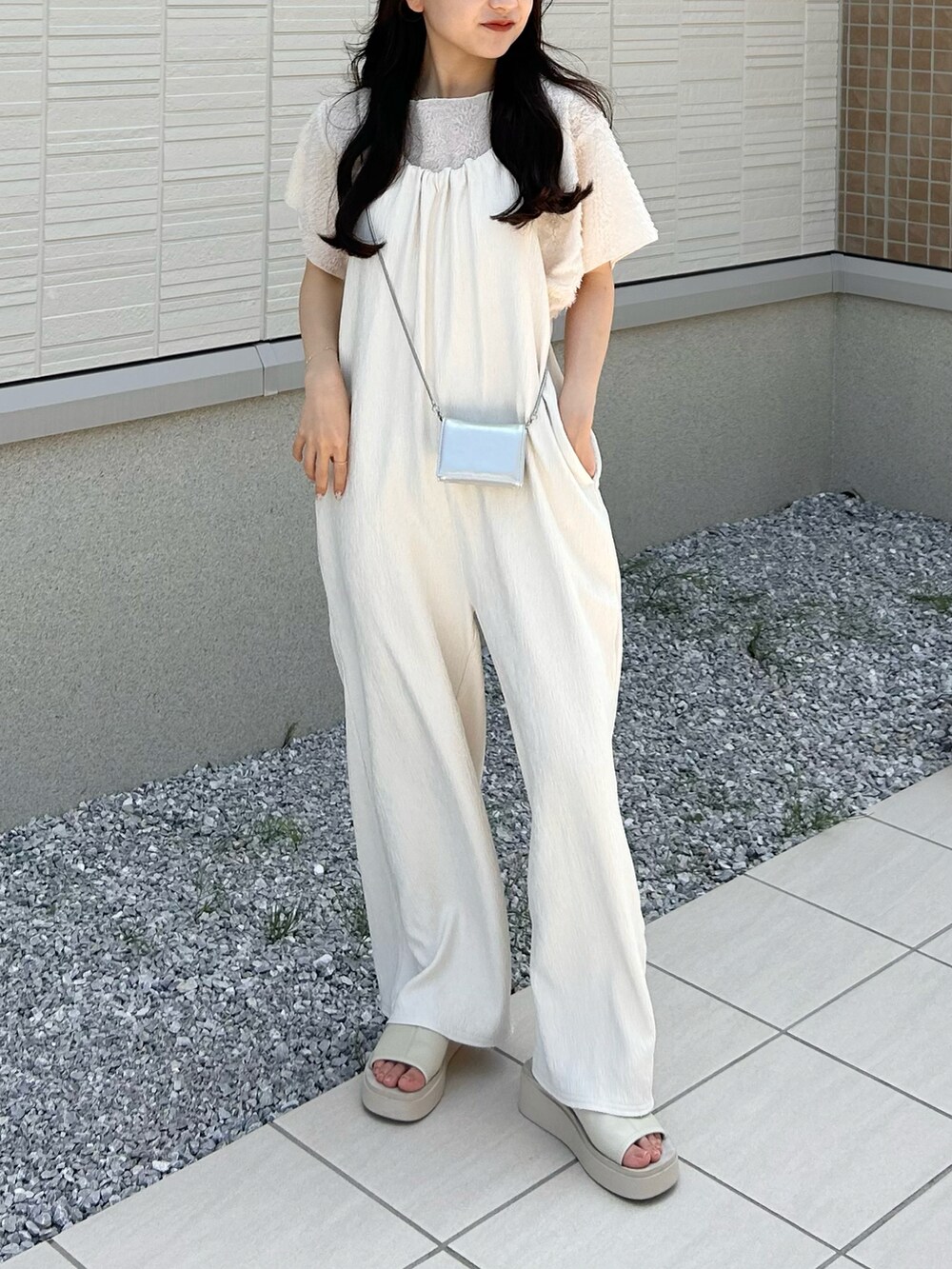 ホワイト系のサンダル、ホワイト系のサロペット/オーバーオール、シルバー系のショルダーバッグを着用したレディースの夏コーディネートの2枚目の写真