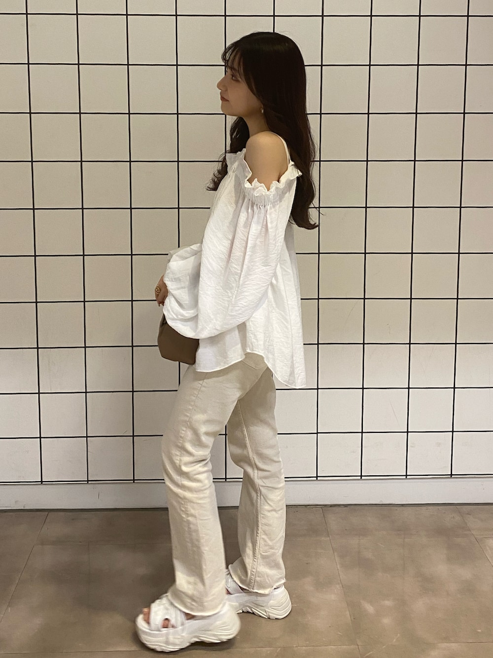 ホワイト系のサンダル、ホワイト系のデニムパンツ、ブラウン系のバッグを着用したレディースの夏コーディネートの2枚目の写真