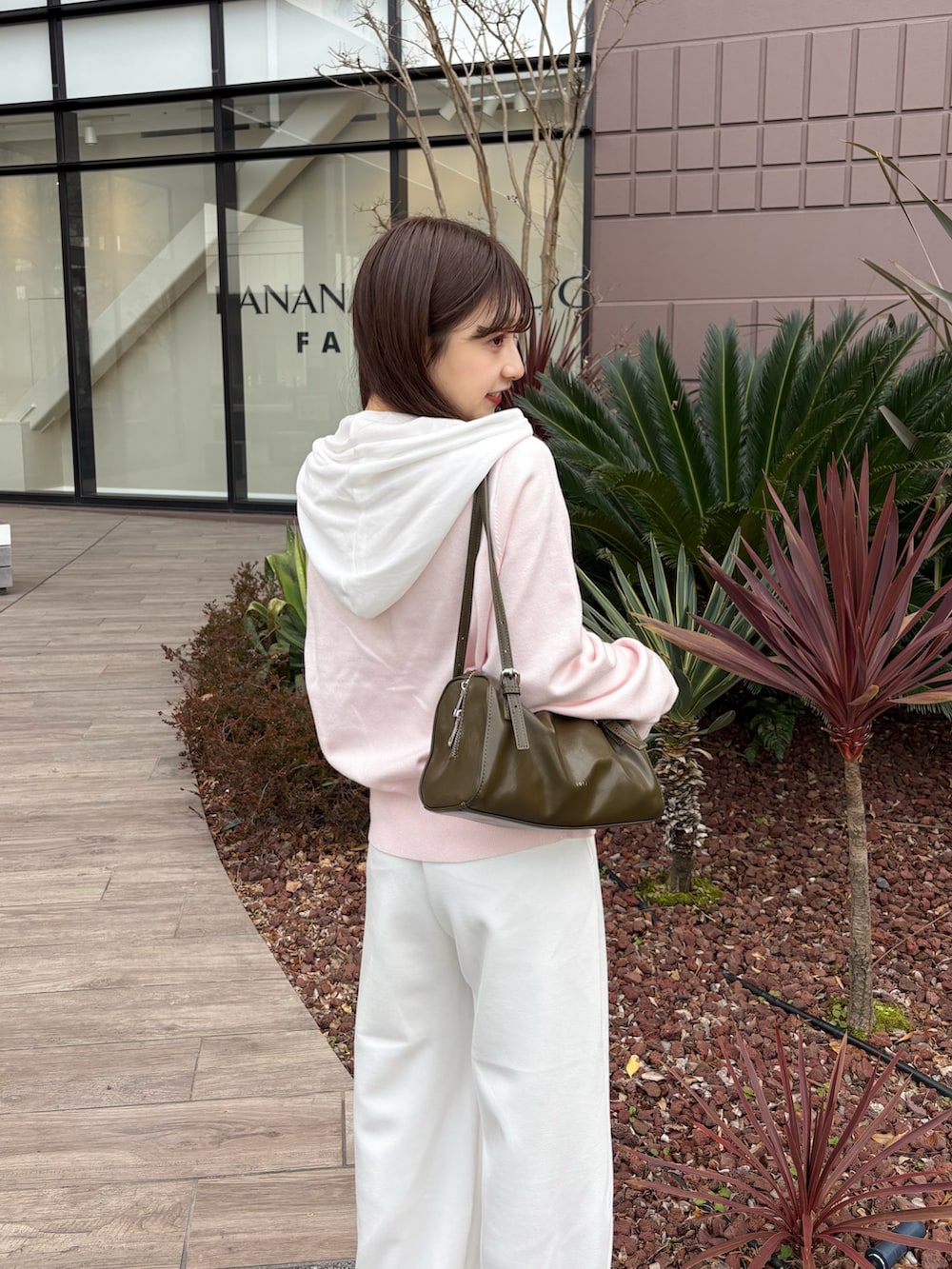 ホワイト系のスウェットパンツ、ピンク系のカーディガン/ボレロ、グリーン系のトートバッグを着用したレディースの春コーディネートの5枚目の写真