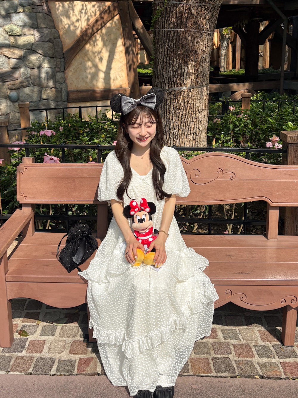 ホワイト系のワンピース、ブラック系のハンドバッグ、ブラック系のシューズを着用したレディースの春コーディネートの2枚目の写真