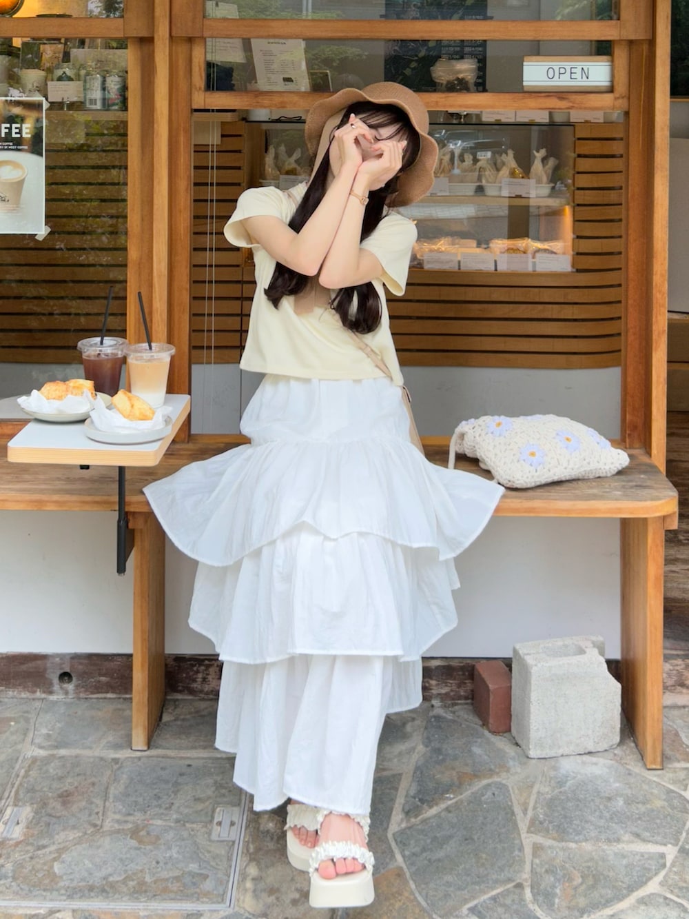 イエロー系のTシャツ/カットソー、ホワイト系のスカート、ホワイト系のサンダルを着用したレディースの夏コーディネートの3枚目の写真