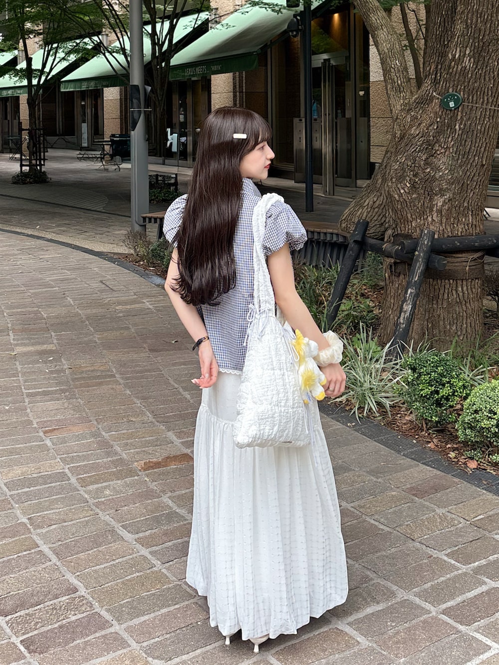 ホワイト系のスカート、ブラック系のシャツ/ブラウス、ホワイト系のトートバッグを着用したレディースの夏コーディネートの2枚目の写真