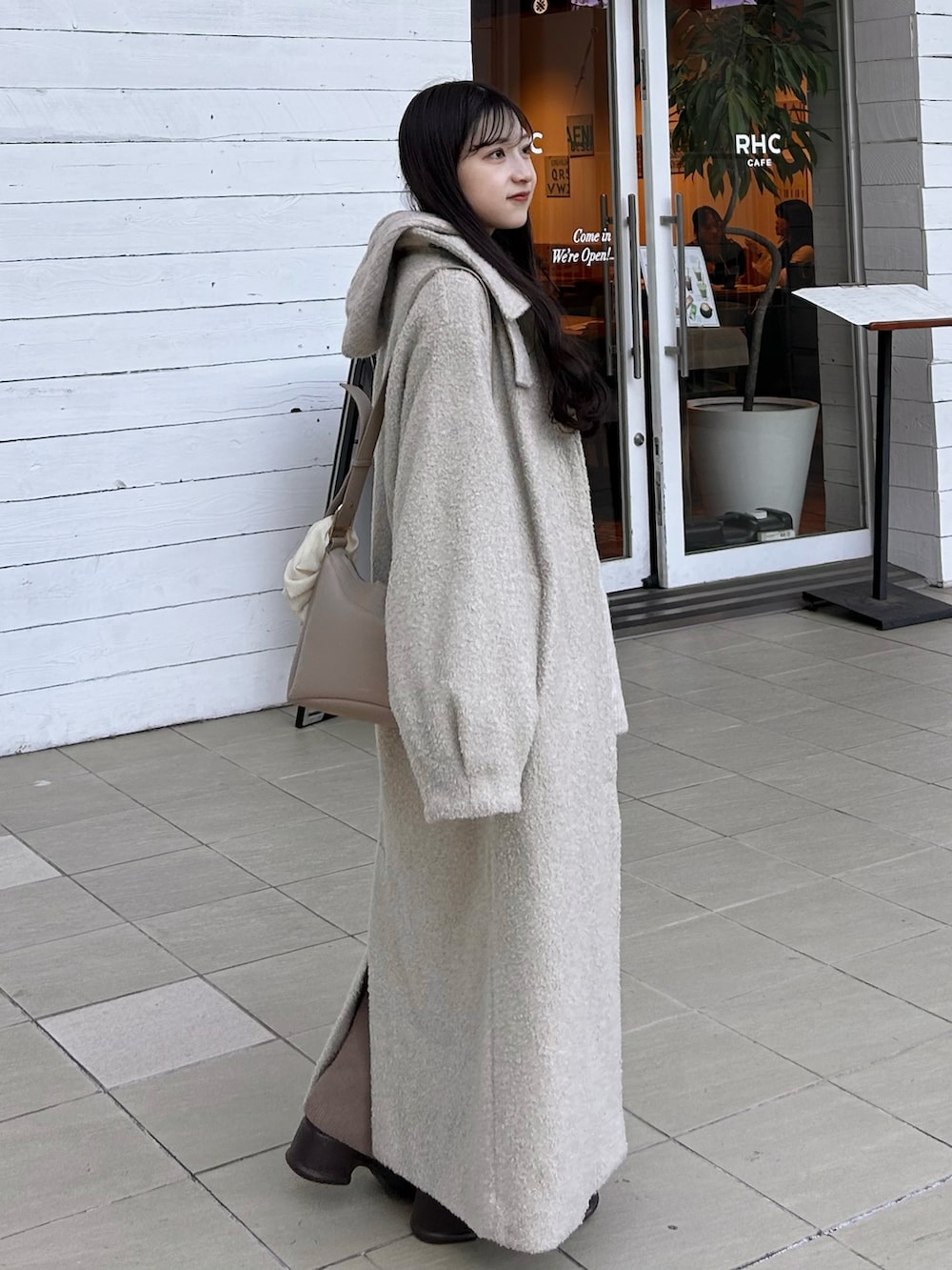 ブラウン系のブーツ、ブラウン系のパンツ、ベージュ系のバッグを着用したレディースの冬コーディネートの2枚目の写真