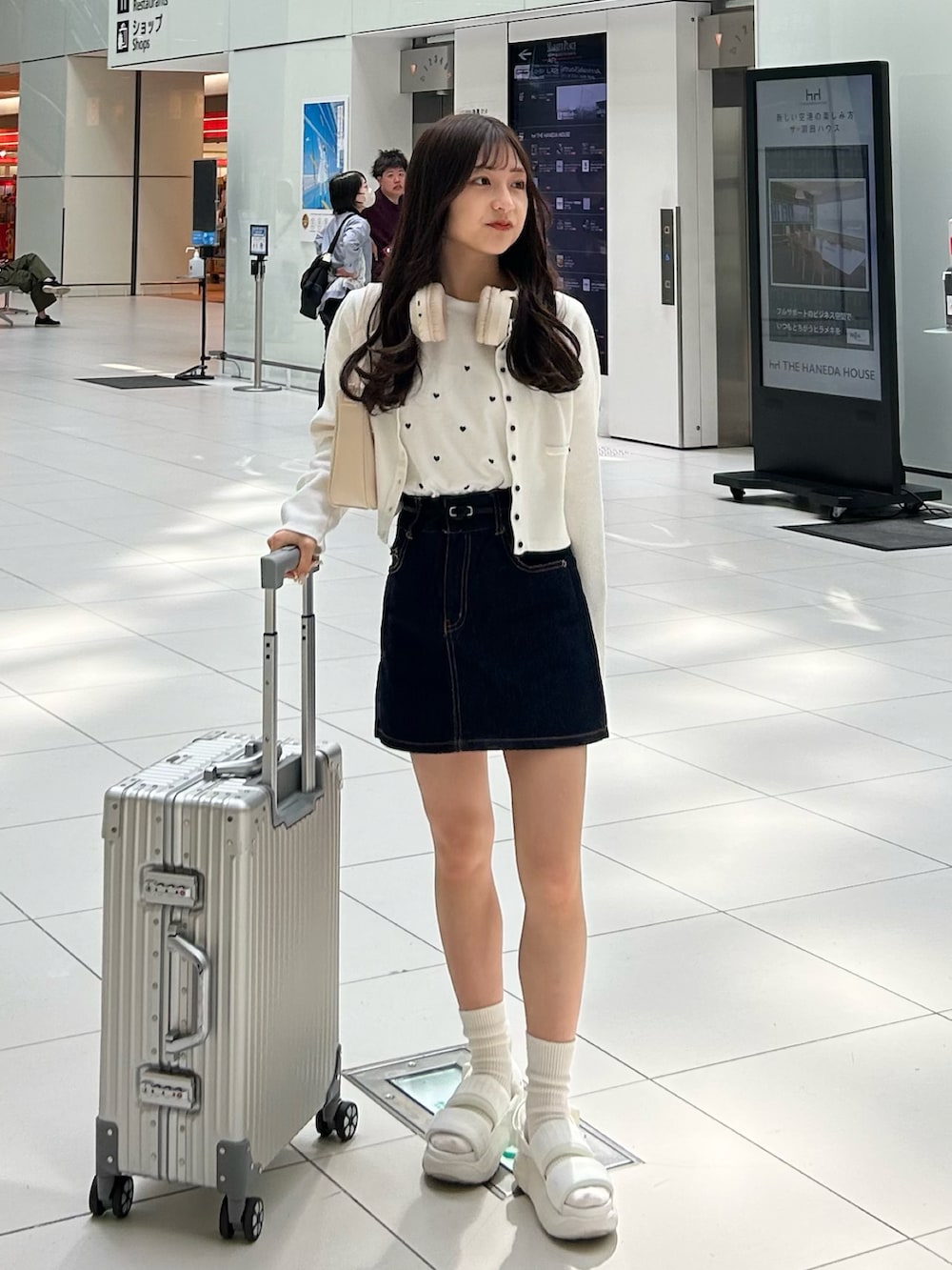 ブルー系のデニムスカート、ホワイト系のTシャツ/カットソー、ホワイト系のカーディガン/ボレロを着用したレディースの春コーディネートの3枚目の写真