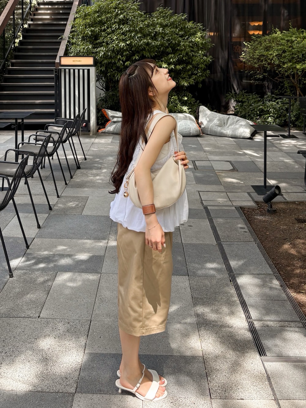 ホワイト系のシャツ/ブラウス、ベージュ系のその他パンツ、ホワイト系のサンダルを着用したレディースの夏コーディネートの3枚目の写真