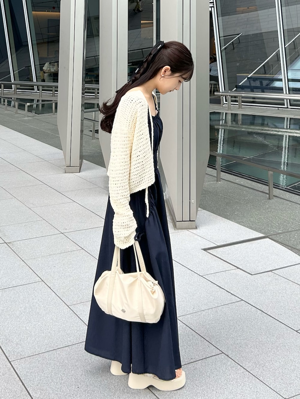 ブルー系のワンピース、ホワイト系のニット/セーター、ホワイト系のハンドバッグを着用したレディースの夏コーディネートの3枚目の写真