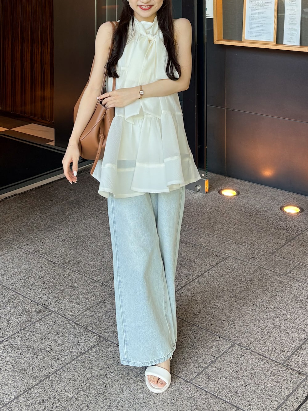 ホワイト系のサンダル、ホワイト系のシャツ/ブラウス、ブルー系のデニムパンツを着用したレディースの夏コーディネートの3枚目の写真