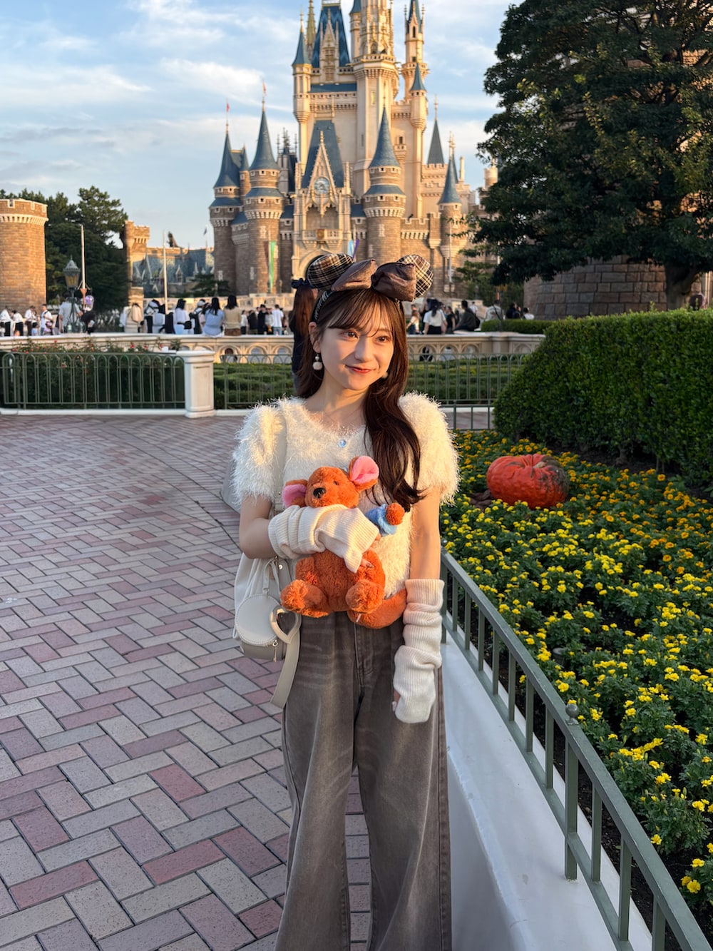 ブラウン系のパンプス、ブラウン系のデニムパンツ、ホワイト系のボストンバッグを着用したレディースの秋コーディネートの4枚目の写真