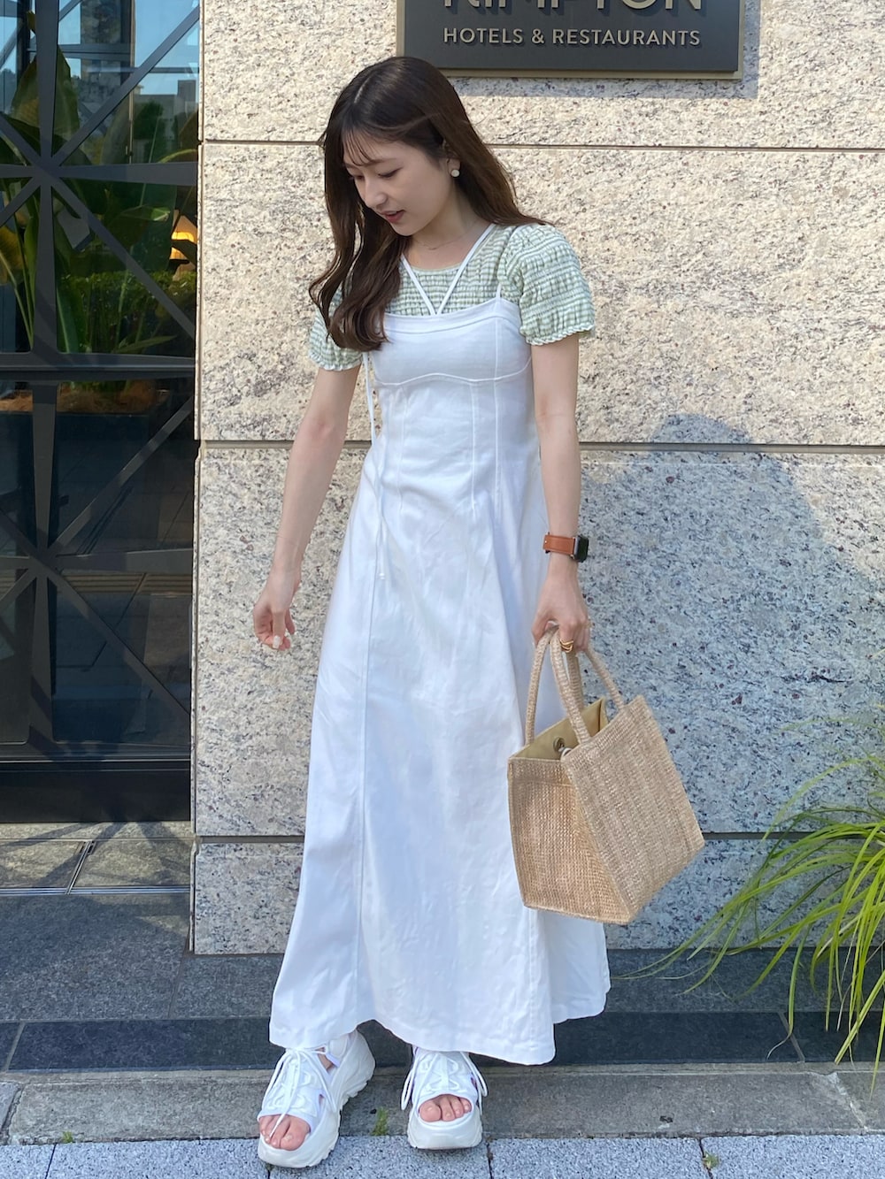 ホワイト系のサンダル、ホワイト系のワンピース、ベージュ系のトートバッグを着用したレディースの夏コーディネートの3枚目の写真