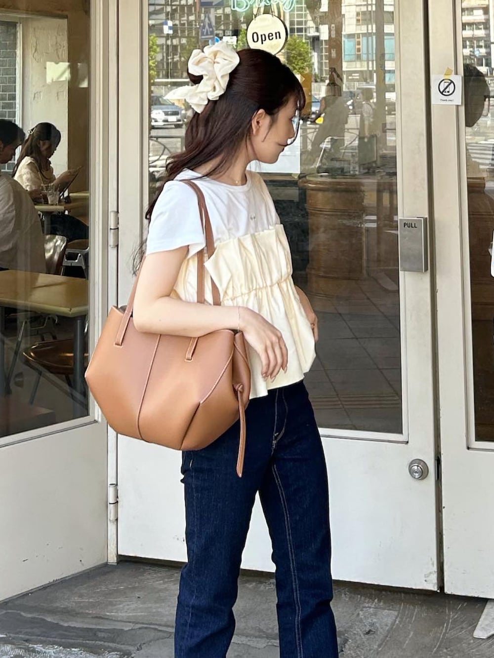 ブラウン系のバッグ、ホワイト系のサンダル、ホワイト系のTシャツ/カットソーを着用したレディースの夏コーディネートの3枚目の写真