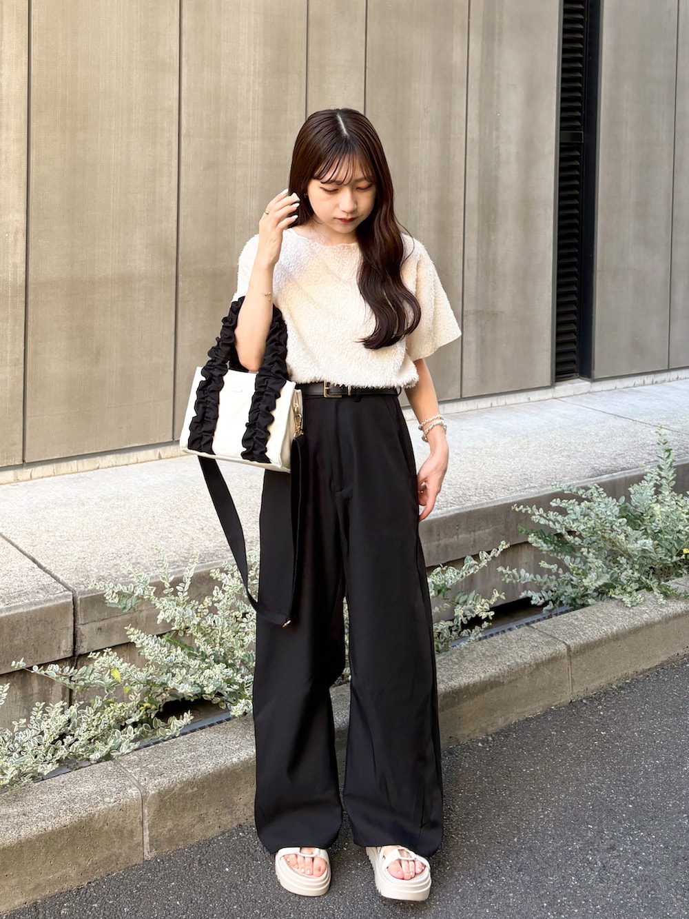 ブラック系のスラックス、ベージュ系のサンダル、ホワイト系のTシャツ/カットソーを着用したレディースの夏コーディネートの4枚目の写真