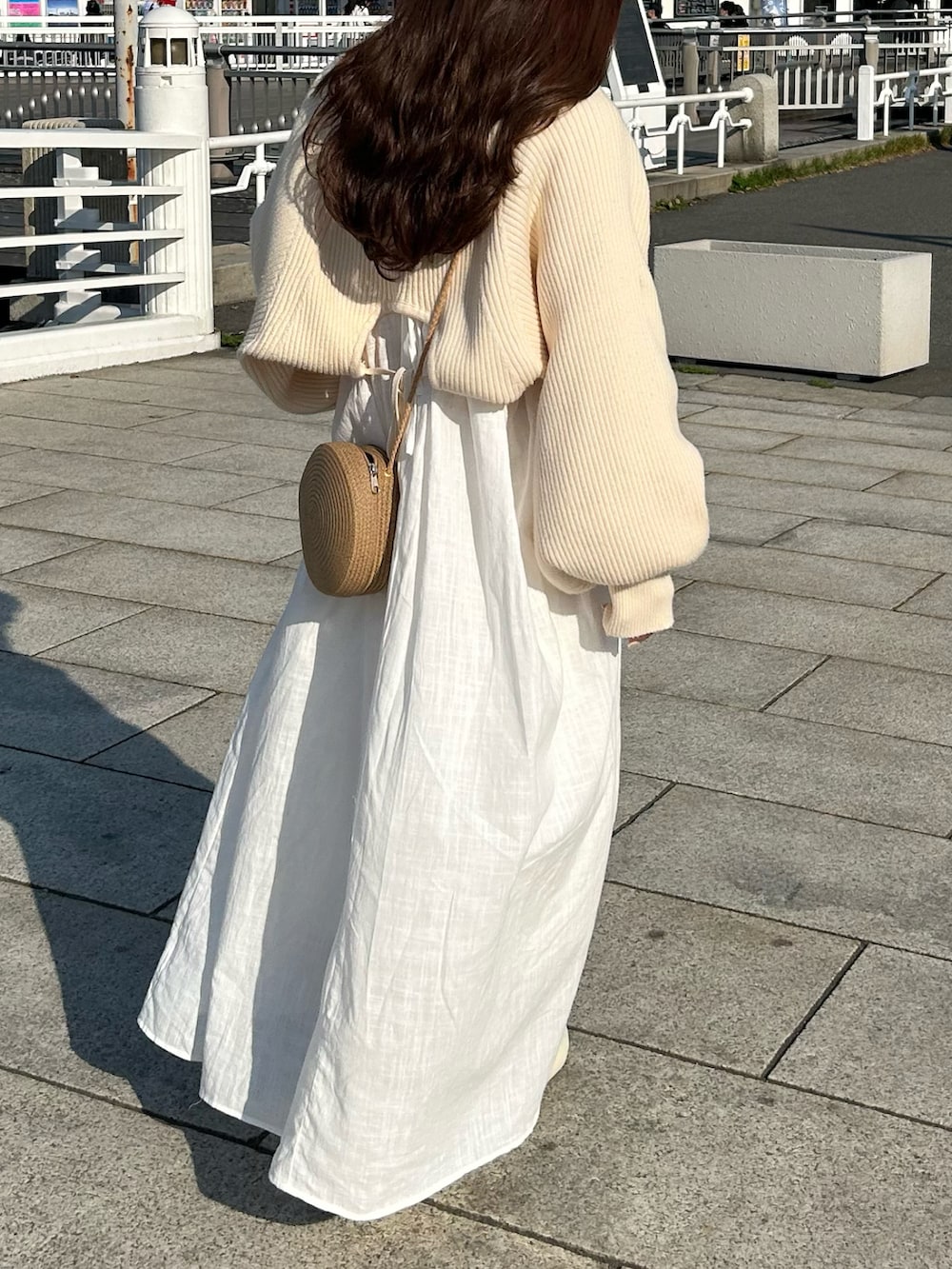 ホワイト系のワンピース、ホワイト系のカーディガン/ボレロ、ホワイト系のサンダルを着用したレディースの春コーディネートの3枚目の写真