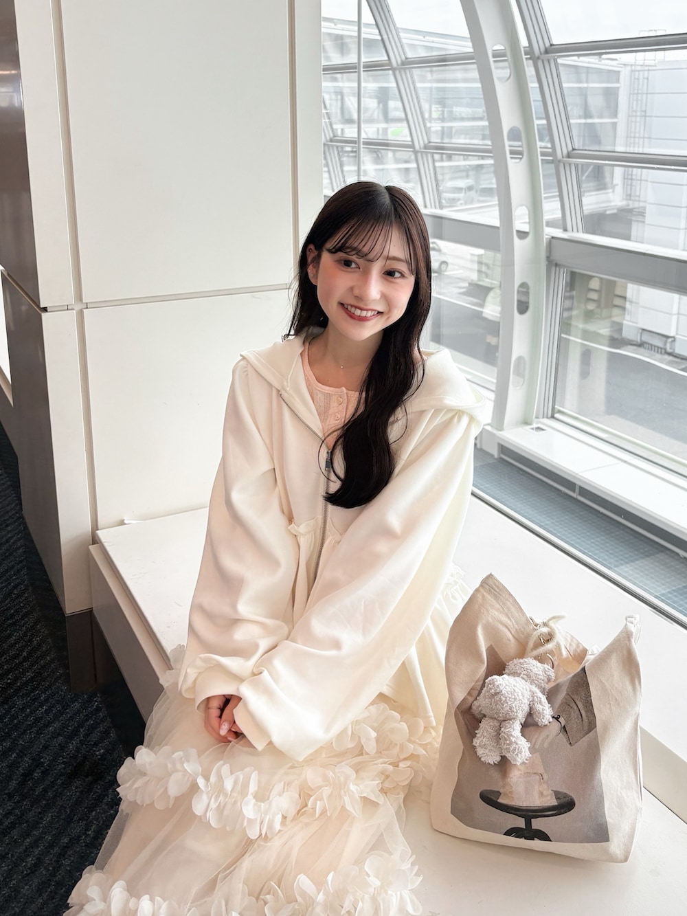 ホワイト系のパーカー、ホワイト系のスカート、ピンク系のTシャツ/カットソーを着用したレディースの夏コーディネートの3枚目の写真