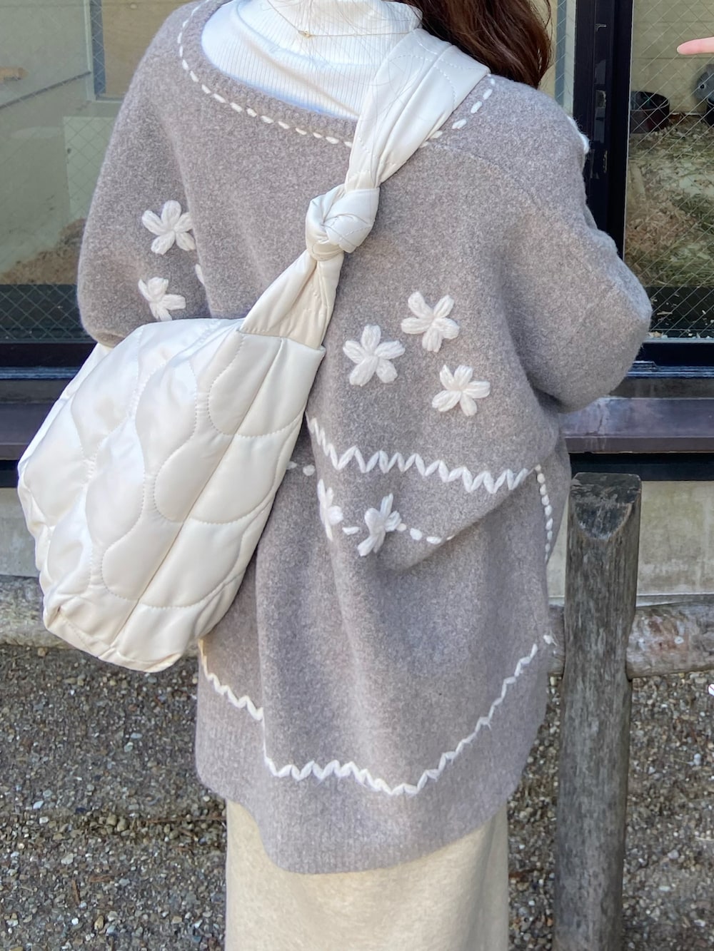 ホワイト系のローファー、ベージュ系のニット/セーター、ホワイト系のショルダーバッグを着用したレディースの冬コーディネートの3枚目の写真