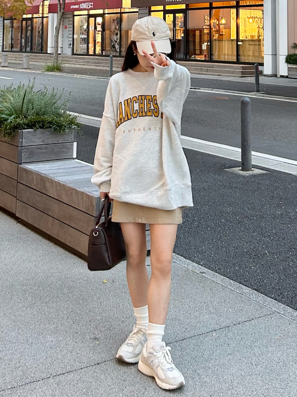 ベージュ系のデニムスカート、ベージュ系のスウェット、グレー系のスニーカーを着用したレディースの秋コーディネートの5枚目の写真