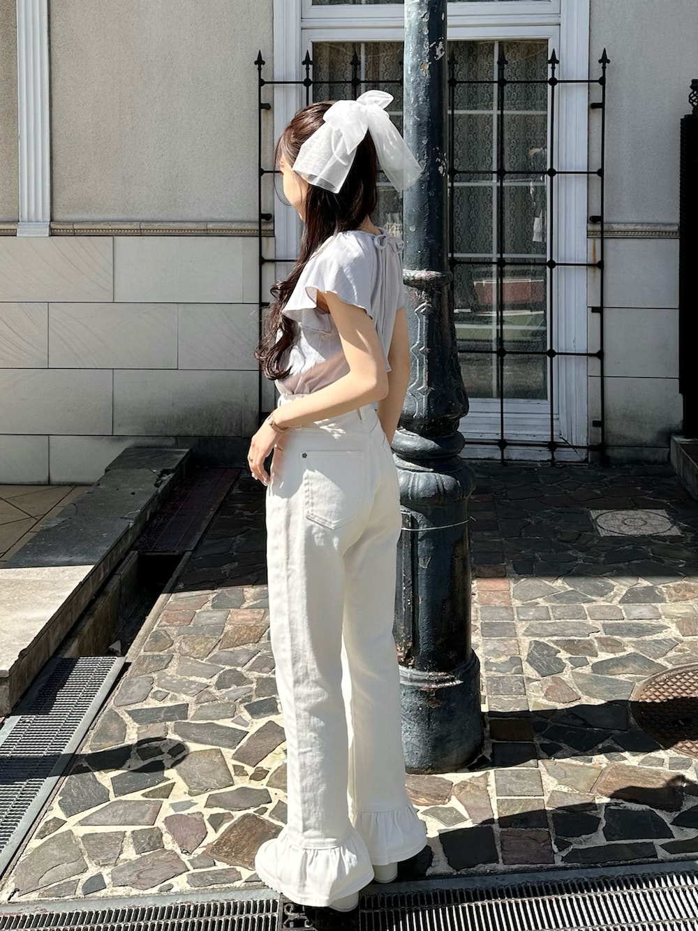 ブルー系のTシャツ/カットソー、ホワイト系のデニムパンツ、ホワイト系のパンプスを着用したレディースの春コーディネートの5枚目の写真