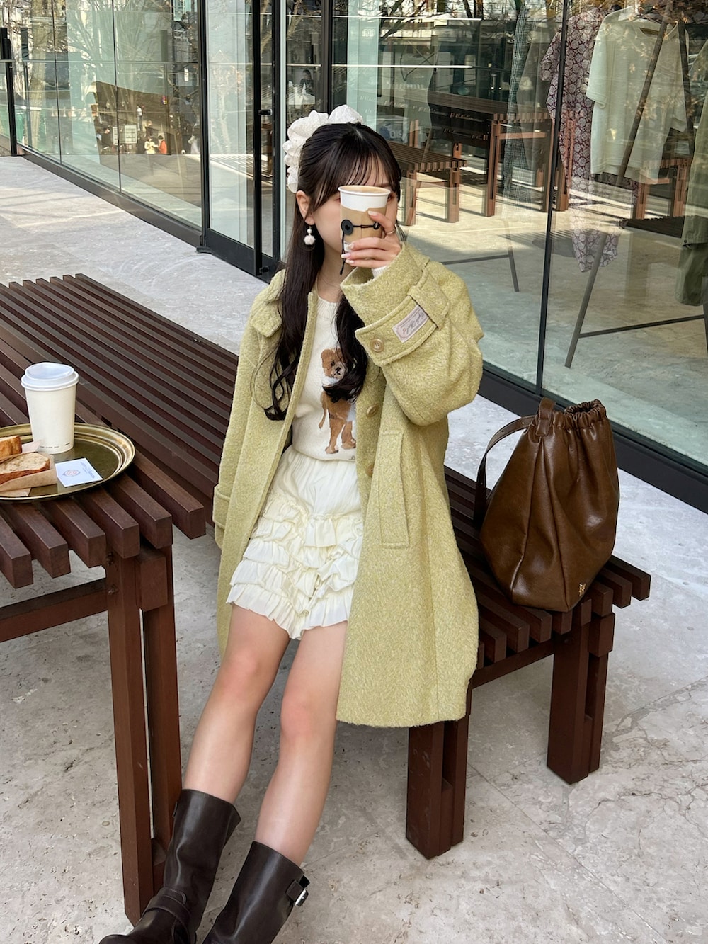 ブラウン系のブーツ、イエロー系のその他アウター、ブラウン系のショルダーバッグを着用したレディースの冬コーディネートの2枚目の写真