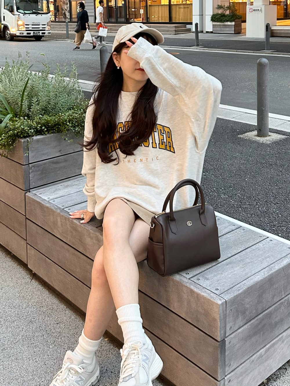 ベージュ系のデニムスカート、ベージュ系のスウェット、グレー系のスニーカーを着用したレディースの秋コーディネートの4枚目の写真