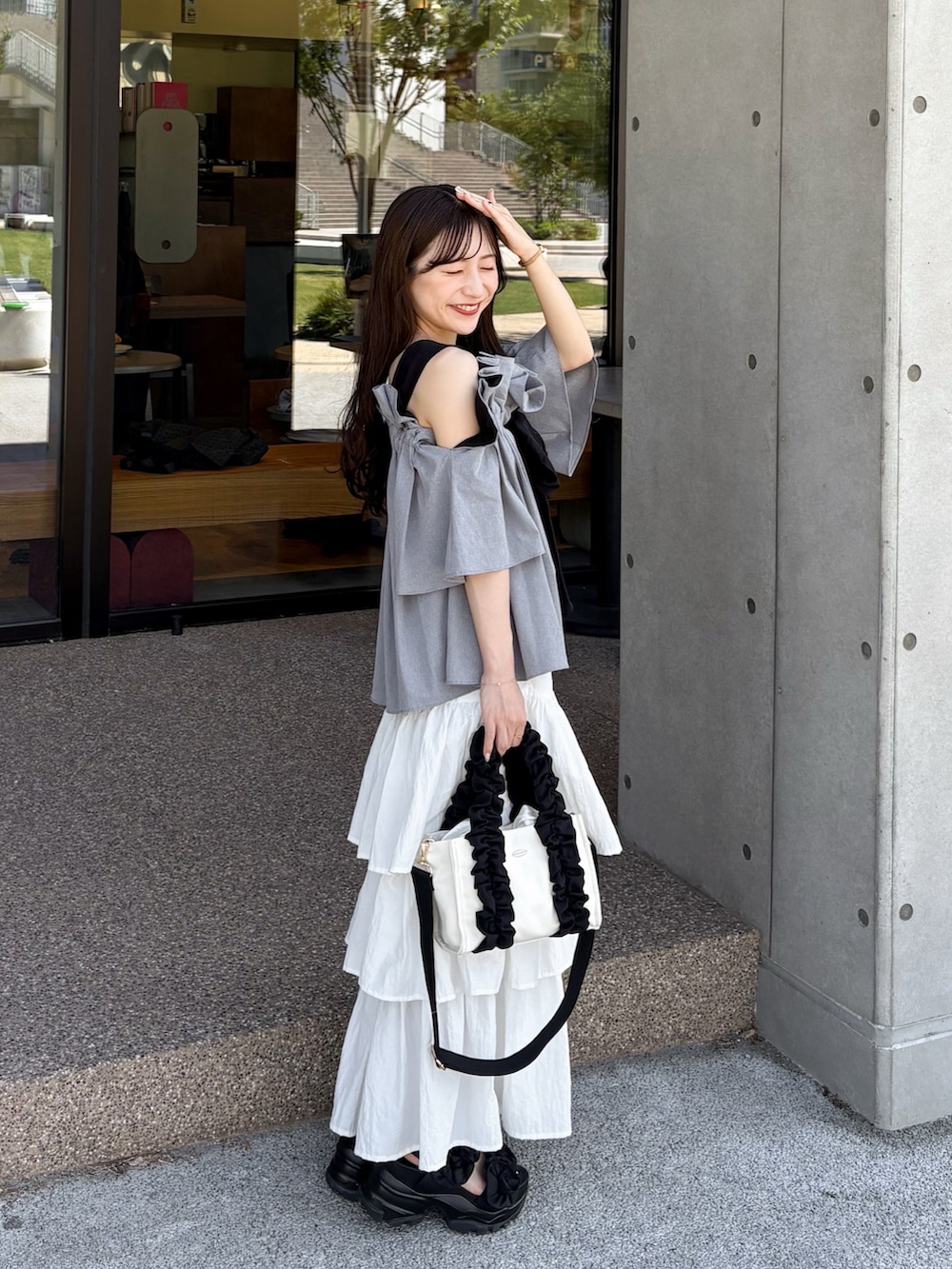 グレー系のシャツ/ブラウス、ブラック系のサンダル、ホワイト系のスカートを着用したレディースの夏コーディネートの4枚目の写真