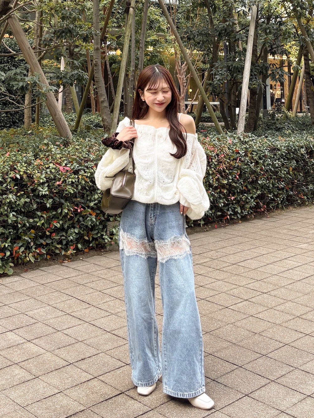 ホワイト系のニット/セーター、ブルー系のデニムパンツ、グリーン系のトートバッグを着用したレディースの秋コーディネートの3枚目の写真