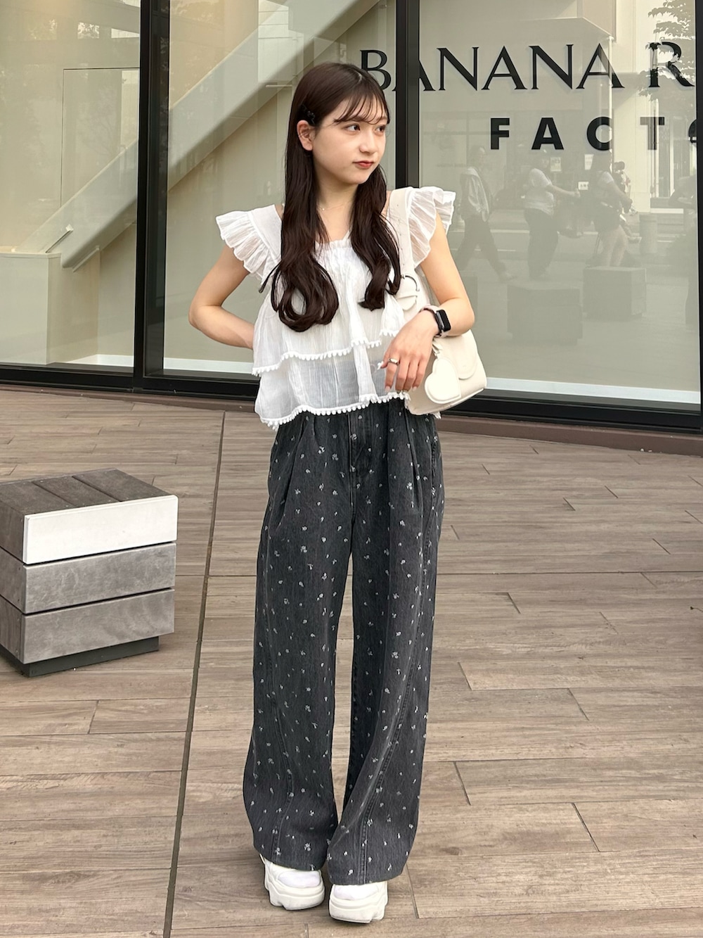 ブラック系のデニムパンツ、ホワイト系のキャミソール、ホワイト系のショルダーバッグを着用したレディースの春コーディネートの5枚目の写真